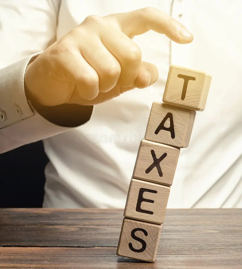 businessman removes wooden blocks with the word taxes the concept of tax payment for housing and property income goods tax 159670952