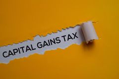 capital gains tax text written in torn paper 163992358