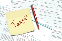 taxes note pen and uk tax forms lying on desk 64721157